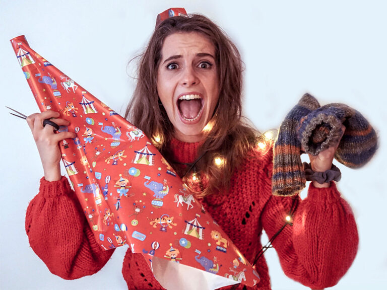 Panische Frau mit Geschenkpapier und Socken in den Händen.