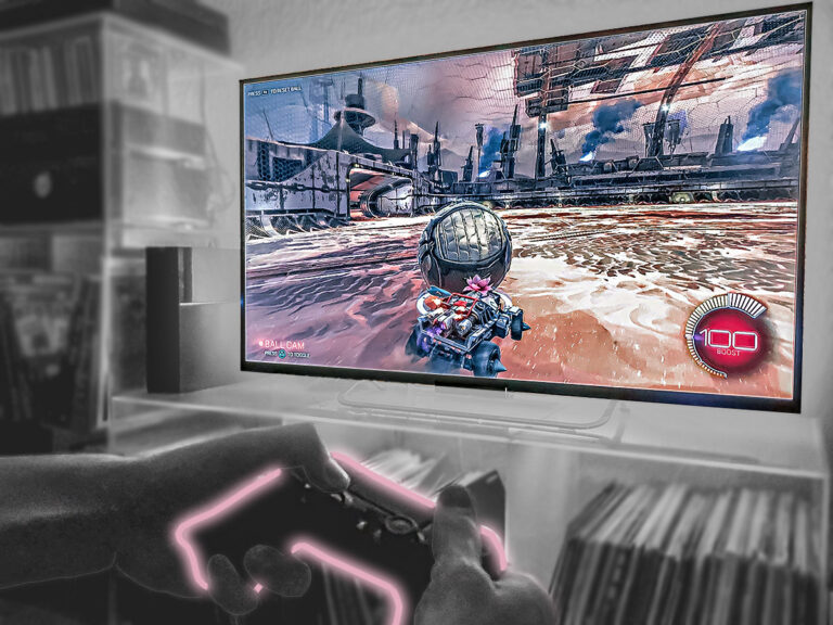 ände mit Controller vor Bildschirm mit E-Sports Autospiel